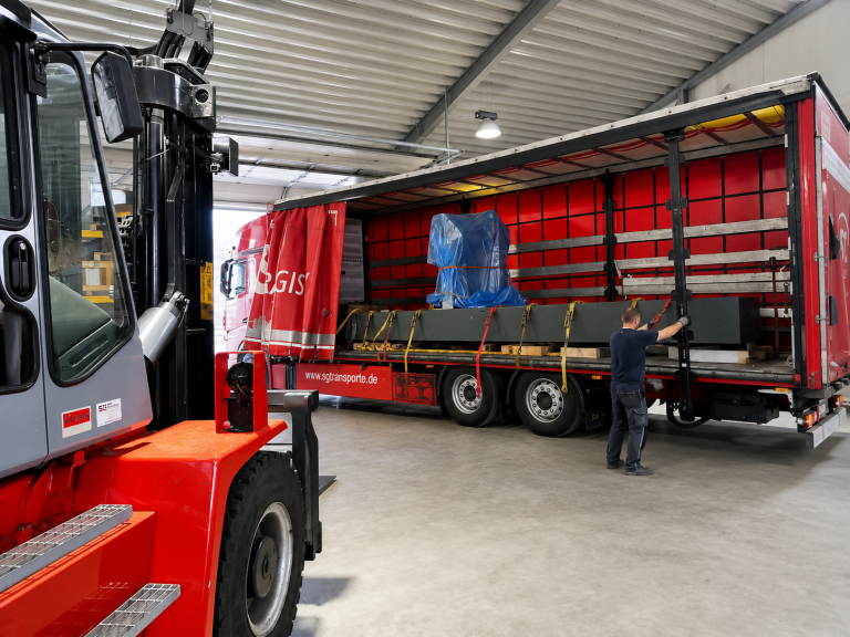 Abbau eines Koordinatenmessgeräts mit Verladung eines großen Granitblocks auf einen LKW zum Abtransport